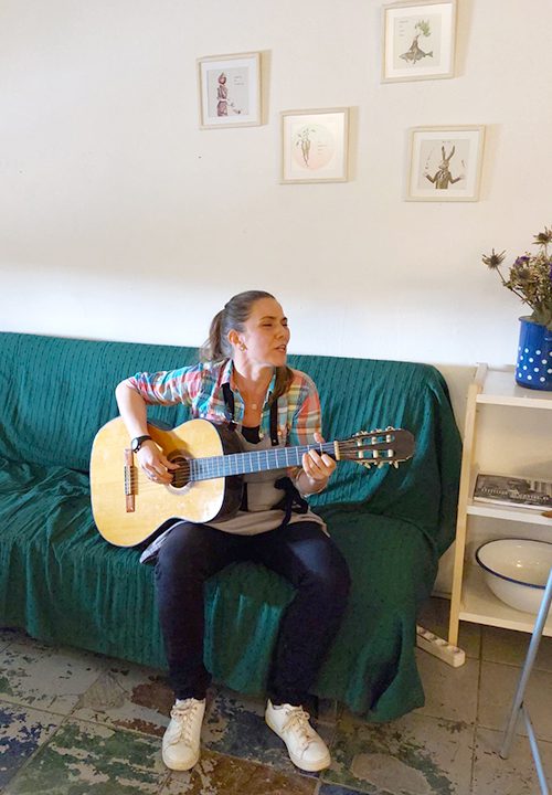 Andrea singing and playing the guitar